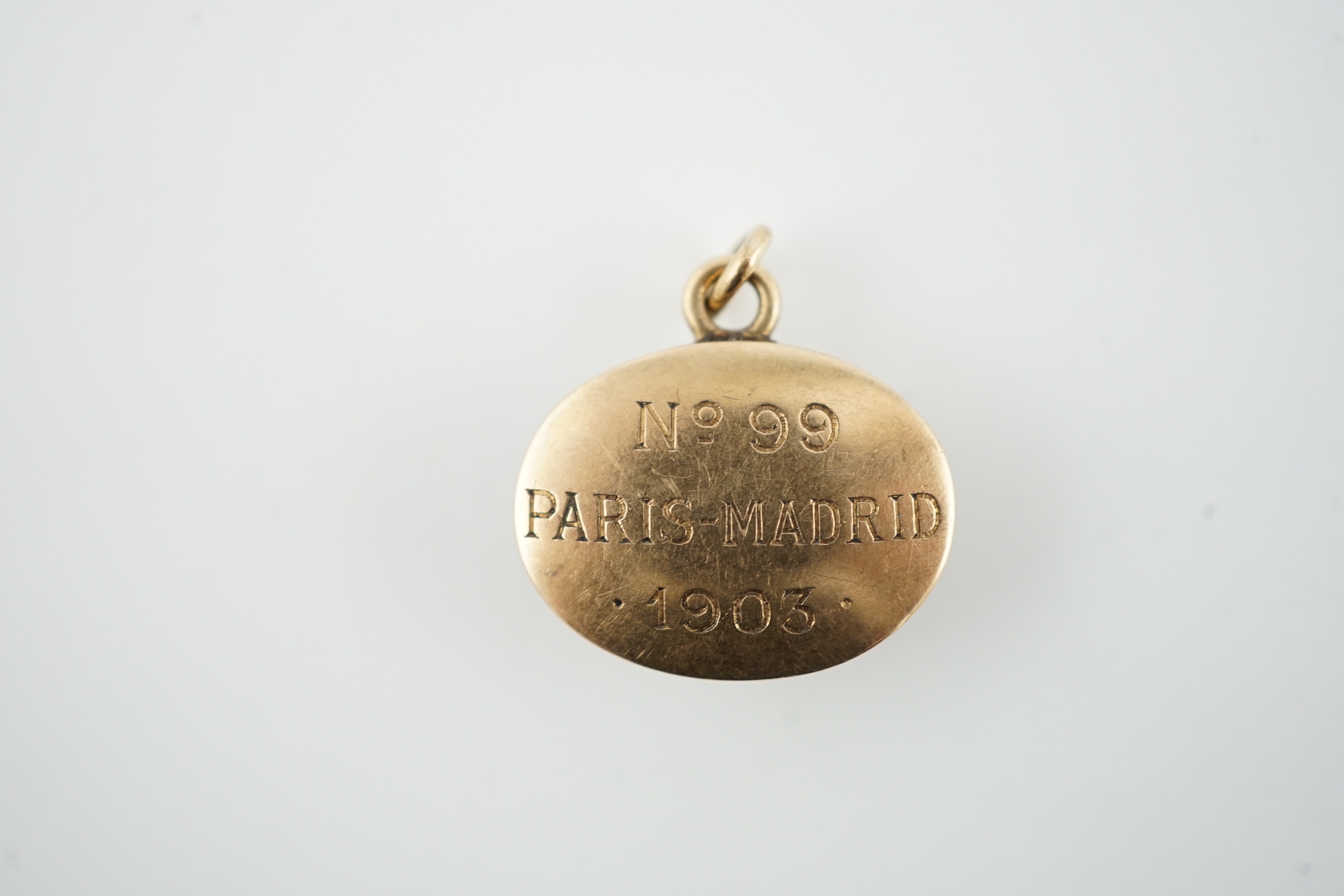 An Edwardian gold and Essex crystal oval fob pendant, commemorating the 1903 Paris-Madrid car race, organised by the Automobile Club de France